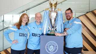The first team content unit in Man City strips with the Premier League trophy
