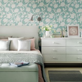 bedroom with floral wallpaper and bed cushions