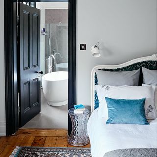 Grey bedroom with wooden floor and en suite bathroom