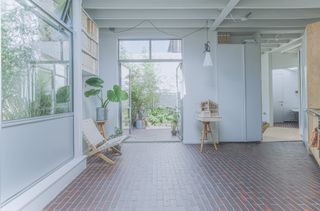 triangle house and its open space, large windows and courtyard with planting all designed by brown urbanism