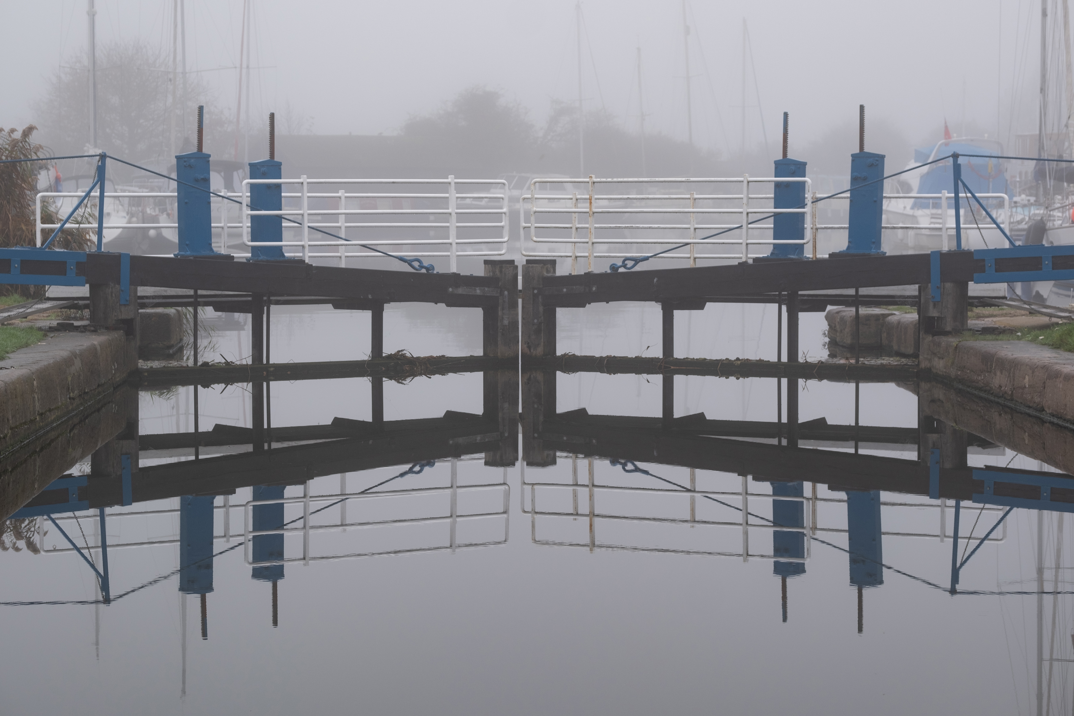 A lock in front of water in the mist