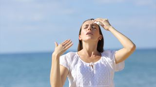 Stressed teen suffering heat stroke on the beach.