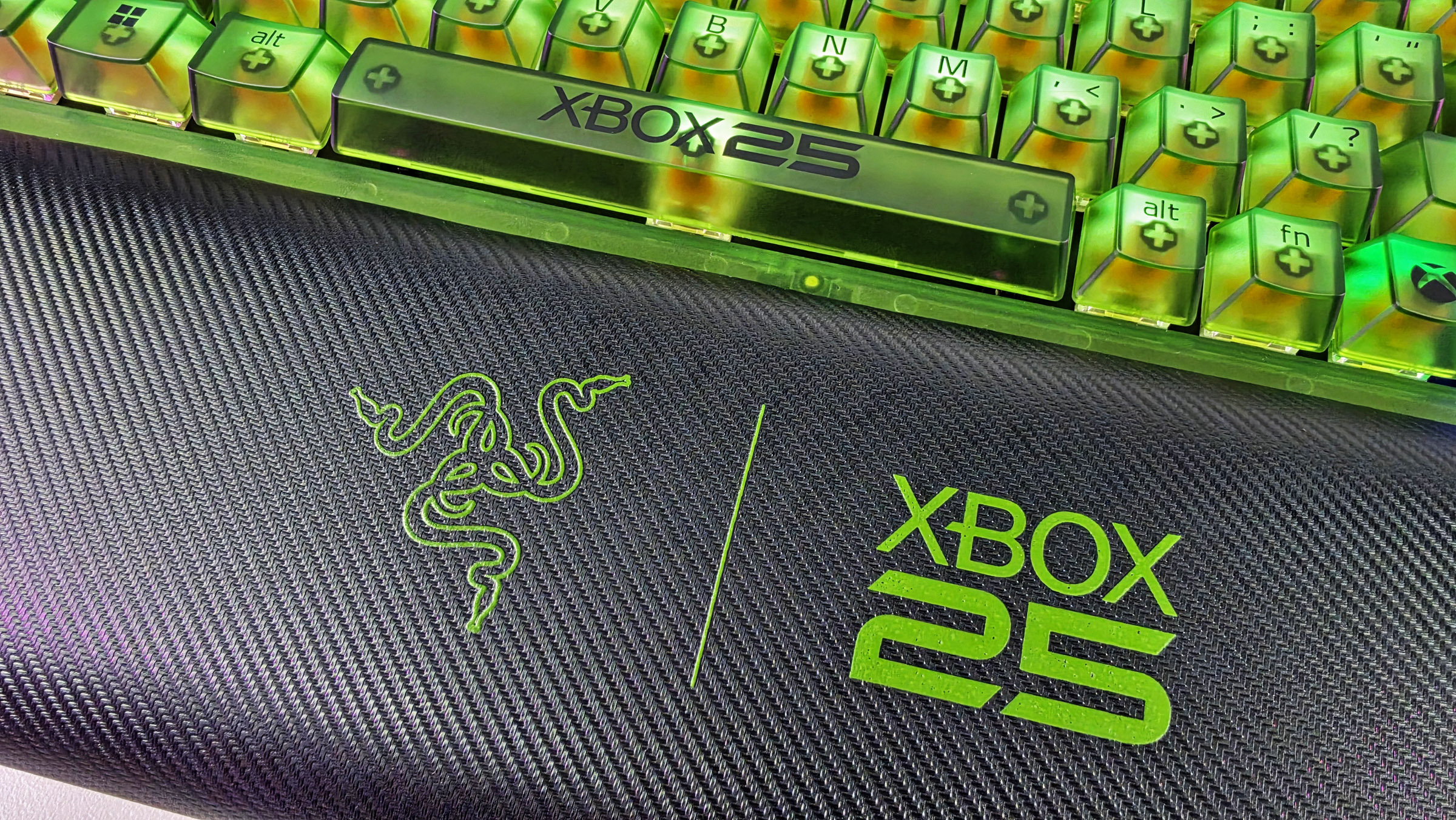 Close-up of the Razer BlackWidow V4 75% wrist rest showing textured faux-leather with green Razer and Xbox 25 logos below the keyboard.