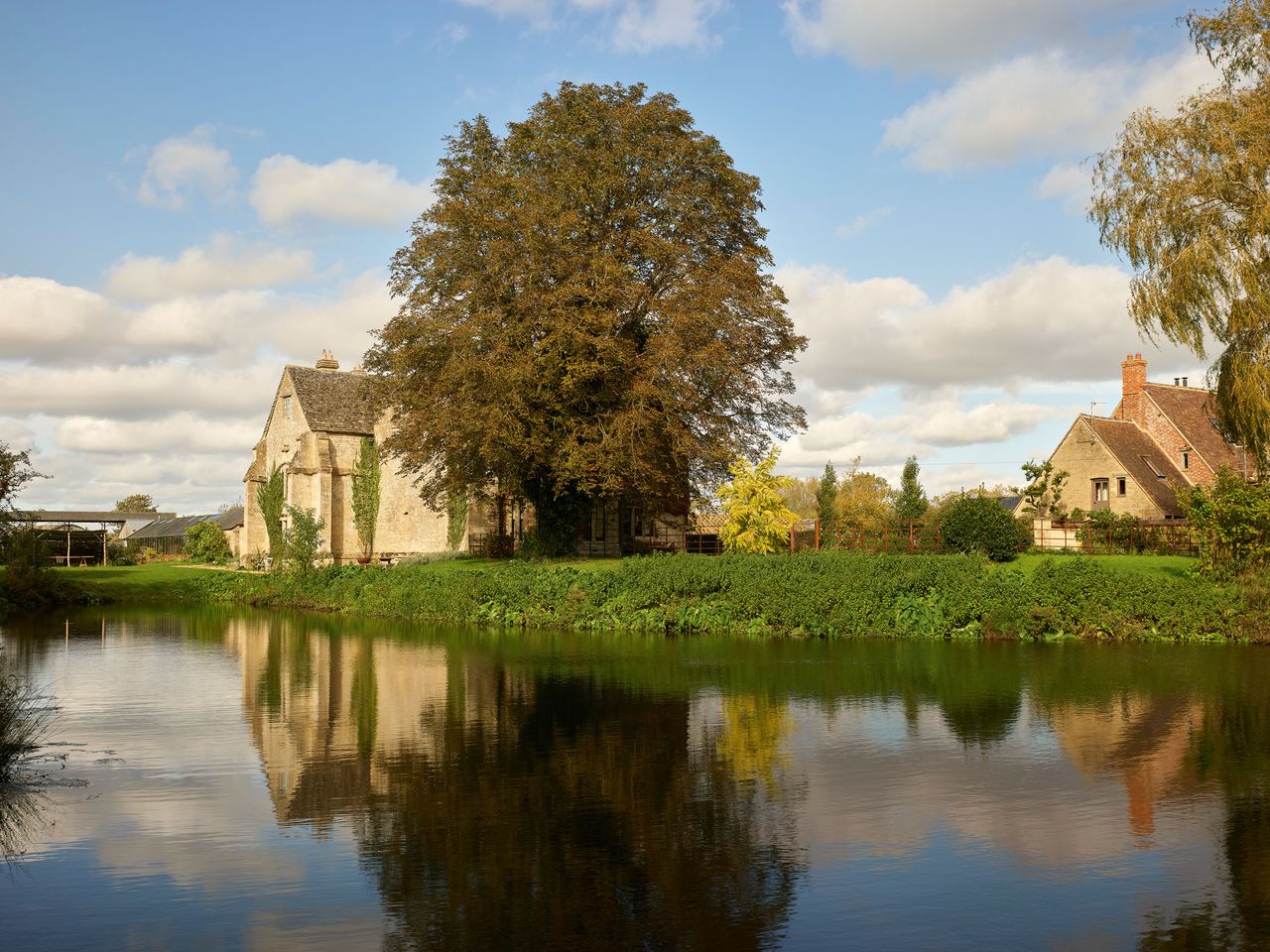 Fig 1: Bampton Castle, now called Ham Court, from the south-west, seen across the waters of the moat. The gatehouse and the short section of wall are all that survive of the medieval stone defences.