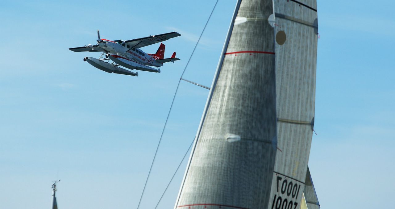 A sea-plane flies past yachts during the start of the Sydney Offshore Newcastle Yacht Race. 