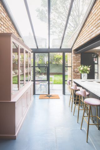 pink and black kitchen with glass roof extension with view to garden