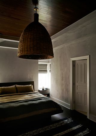An earthy bedroom with brown walls and cane lighting