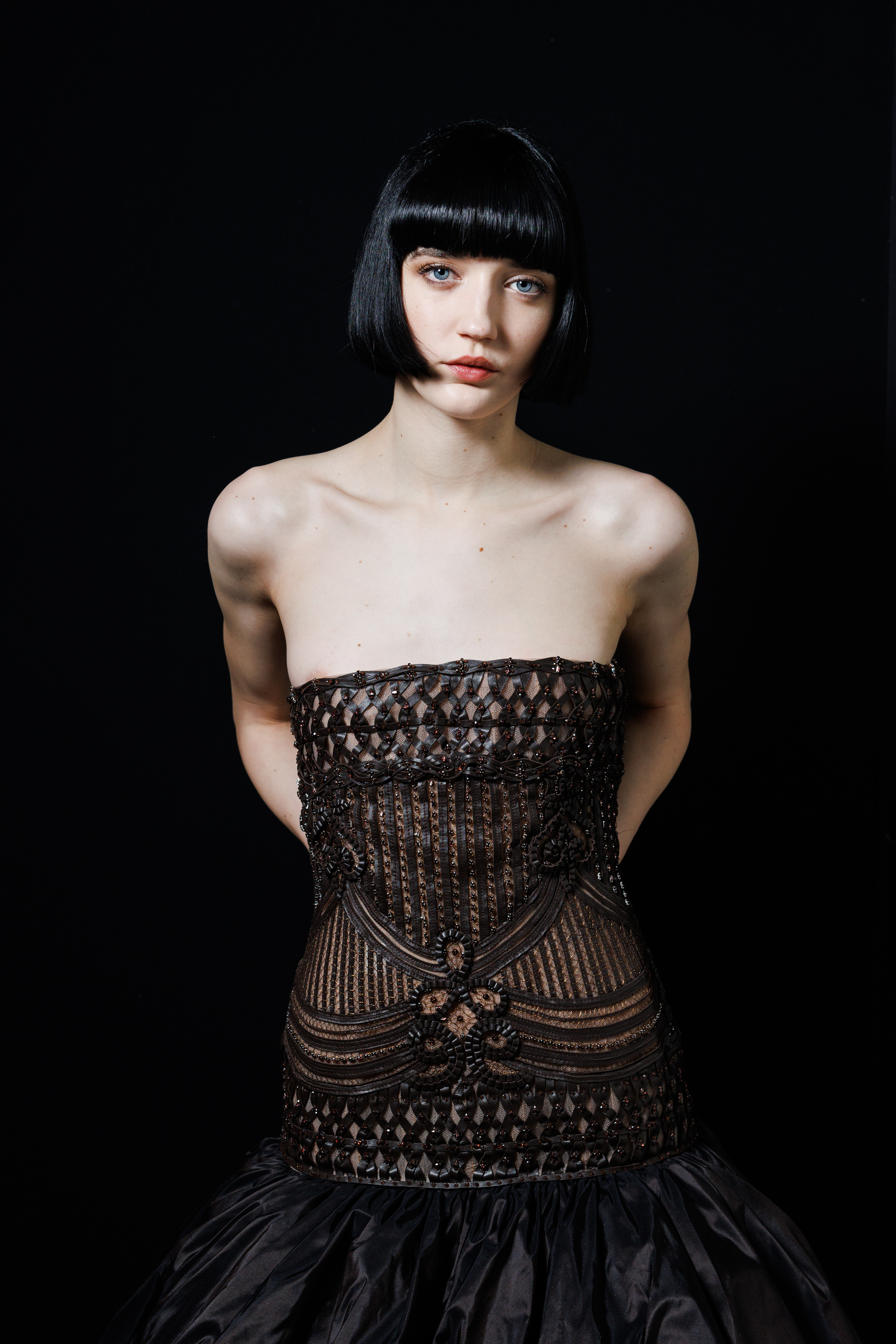 a white woman with a short, black bob backstage at a fashion show