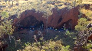 An aerial photo of people in rocky gorge surrounded by brush and trees