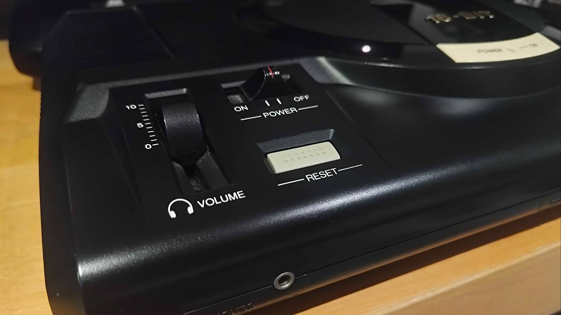 Close up of Sega Mega Drive volume dial, power switch, reset button, and headphone jack.
