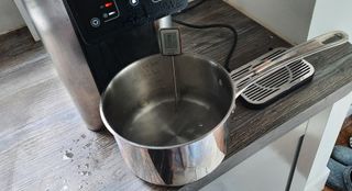 Pouring hot water into a saucepan with the Aqua Optima Aurora