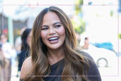 Chrissy Teigen smiling with hair down