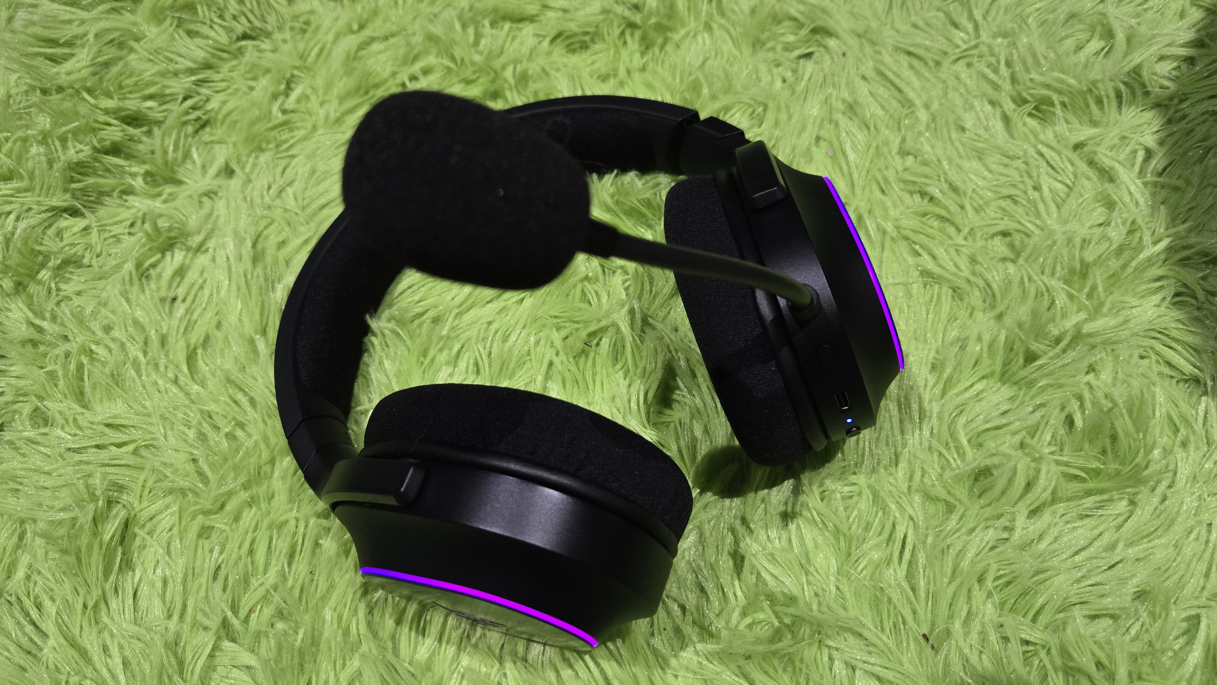 The Razer Barracuda X Chroma wireless gaming headset with a colorful finish on a chair.