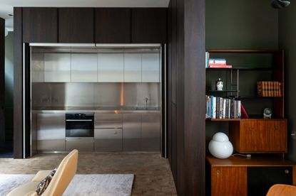 Open invisible kitchen with dark wooden doors