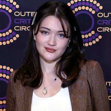 Isa Briones styled dark, low-rise jeans with a white tank top, brown blazer, and matching pumps