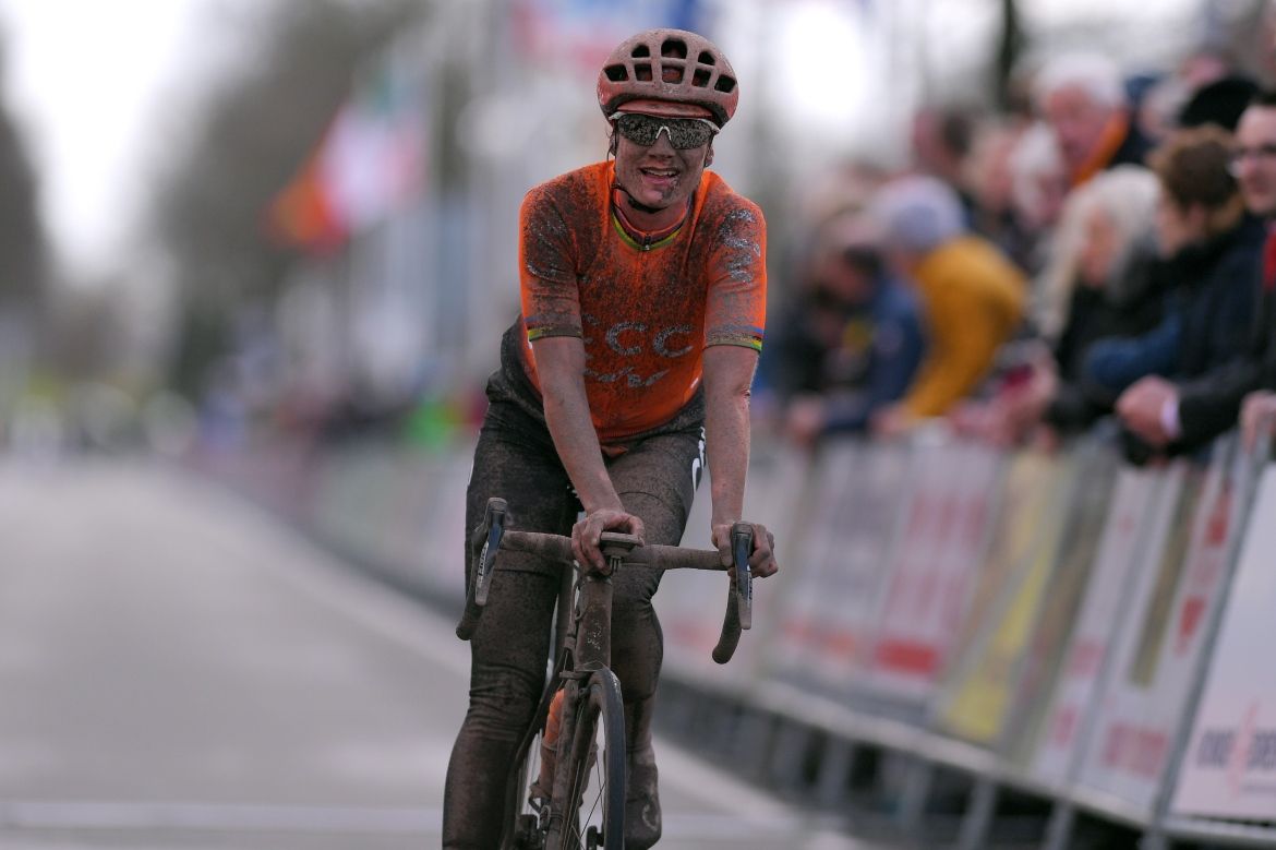 Marianne Vos is covered in mud but she's all smiles as she crosses the line