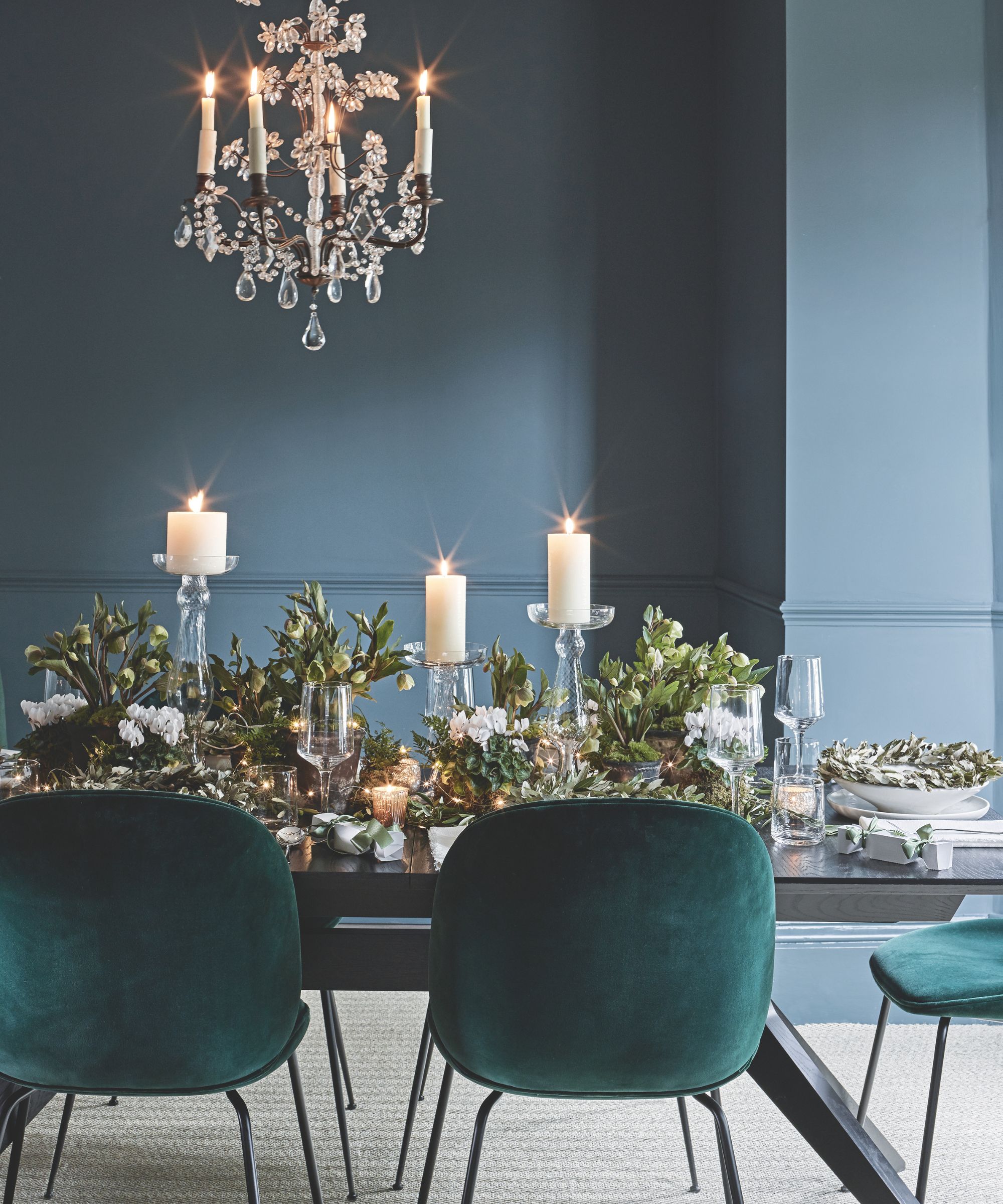 Green dining room with candles and greenery on the table