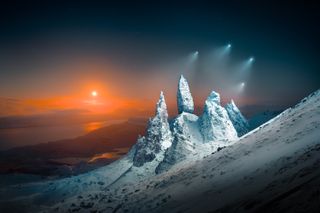 moon rising over the old man of storr in scotland with 4 drones in the air shining lights down