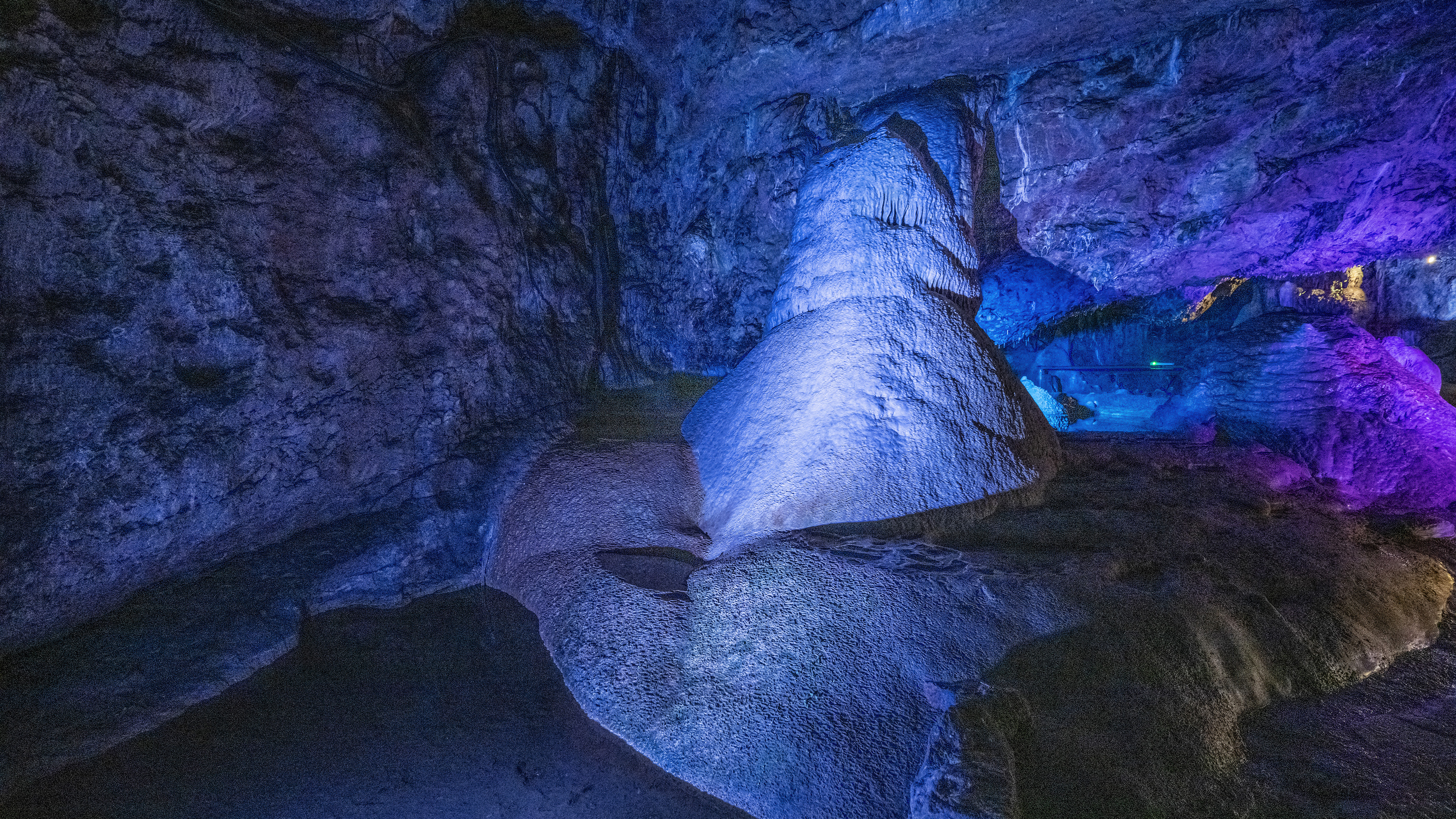 Large stalagmite surrounded by pool of water