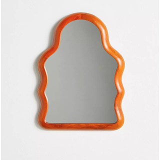 arched wall mirror with a wavy orange border
