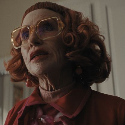 amy madigan as aunt gladys wearing a red jacket and big clear glasses in a still from weapons