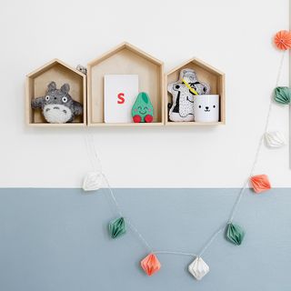 kids room with white and grey wall and wooden shleves and fairy lights