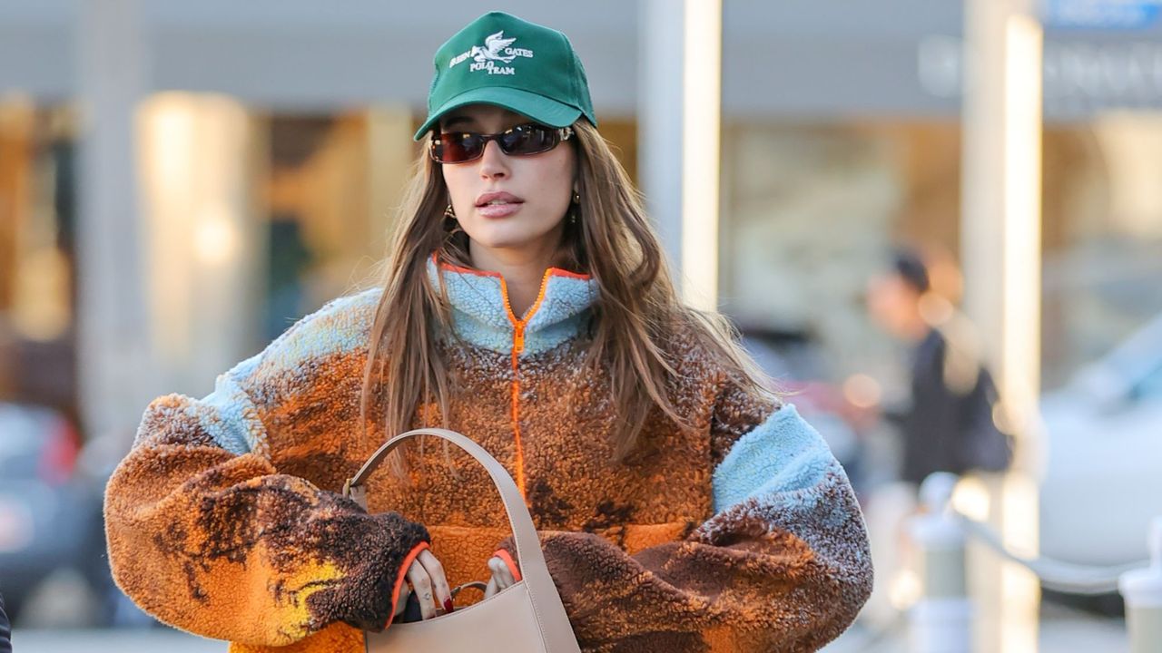 Hailey Bieber out walking wearing a fleece and cap