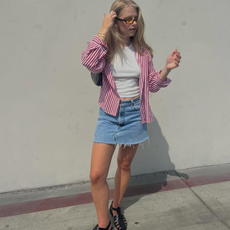 A woman wearing a skirt and striped top.