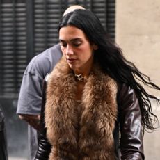 Dua Lipa wearing a brown leather and fur coat in Paris
