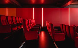 Interior view of a screen at Yorck Kino Passage cinema featuring red walls with vertical strip lights and red seats