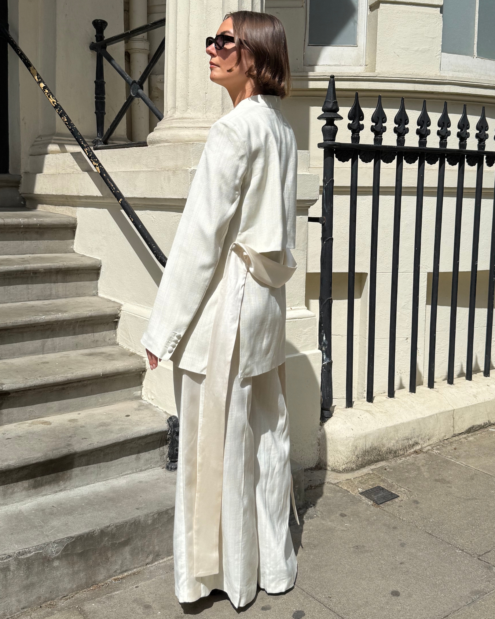 Sophie Robyn Watson wearing a white suit and burgundy heeled shoes from the ROKSANDA x & Other Stories collection.