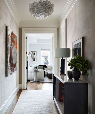 hallway with console and view to living room with white sofas