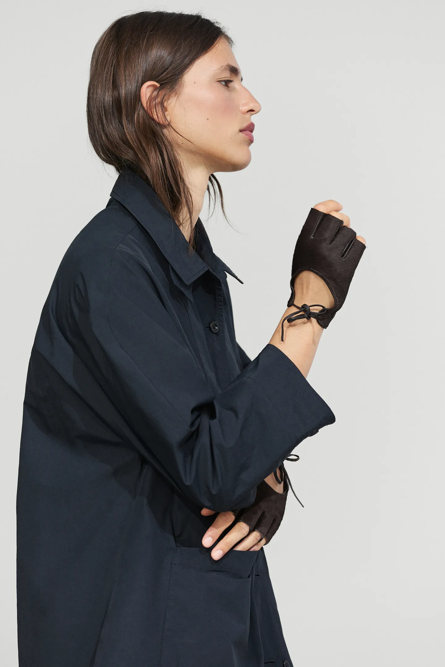 A model wearing a pair of leather fingerless Massimo Dutti gloves.