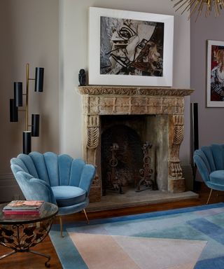 Fireplace in living room with blue scallop velvet chairs