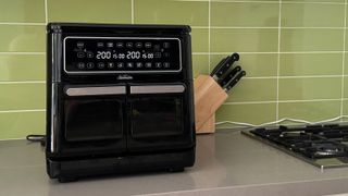 Sunbeam Multi Zone Air Fryer Oven on kitchen counter top, with a knife block in the background