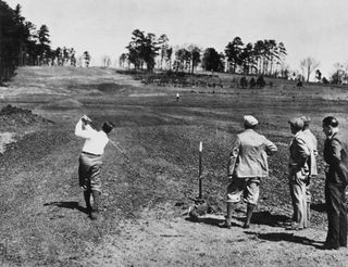 Bobby Jones (left) plays a shot on the eighth hole at Augusta in 1932 while the course was under construction in front of his father, Bob Jones, Sr. (Colonel), Clifford Roberts, and Alister MacKenzie at Augusta National Golf Club in 1932 in Augusta, Georgia. Photo by Augusta National/Getty Images