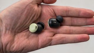 Holding the Google Pixel Buds Pro earbuds in hand