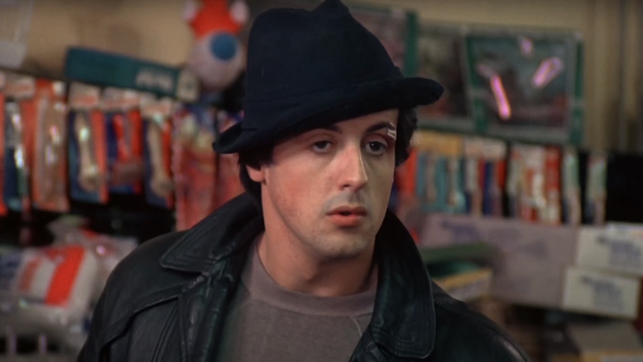 Sylvester Stallone&#039;s Rocky inside pet store wearing his black hat and black leather jacket