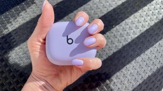 Beats Powerbeats Pro 2 case, held in a woman's hand