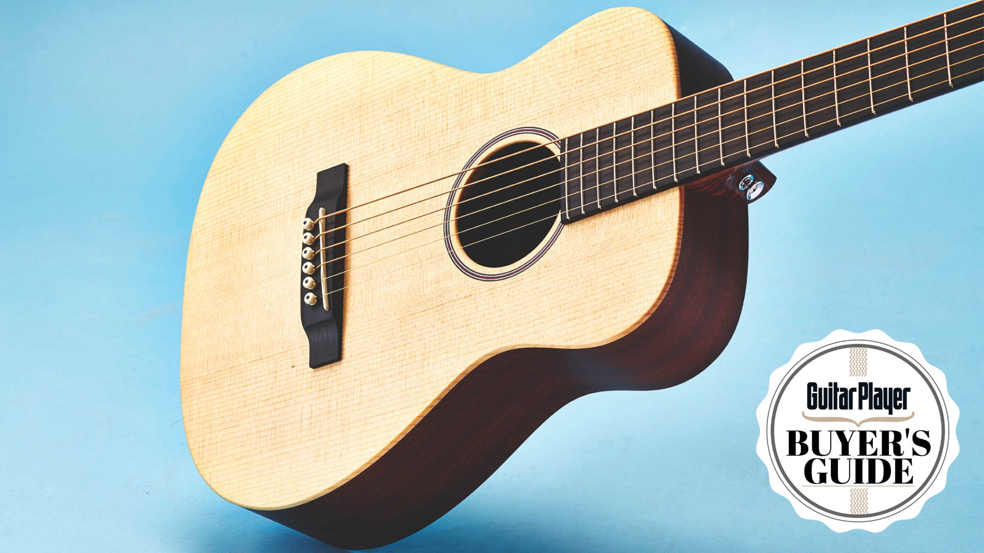 A Martin LX1 acoustic guitar on a light blue background