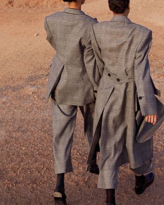 Two women walking in matching suits