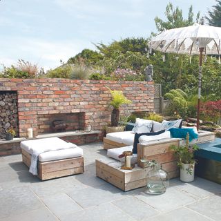 outdoor brick fireplace surrounded by sofa and seating