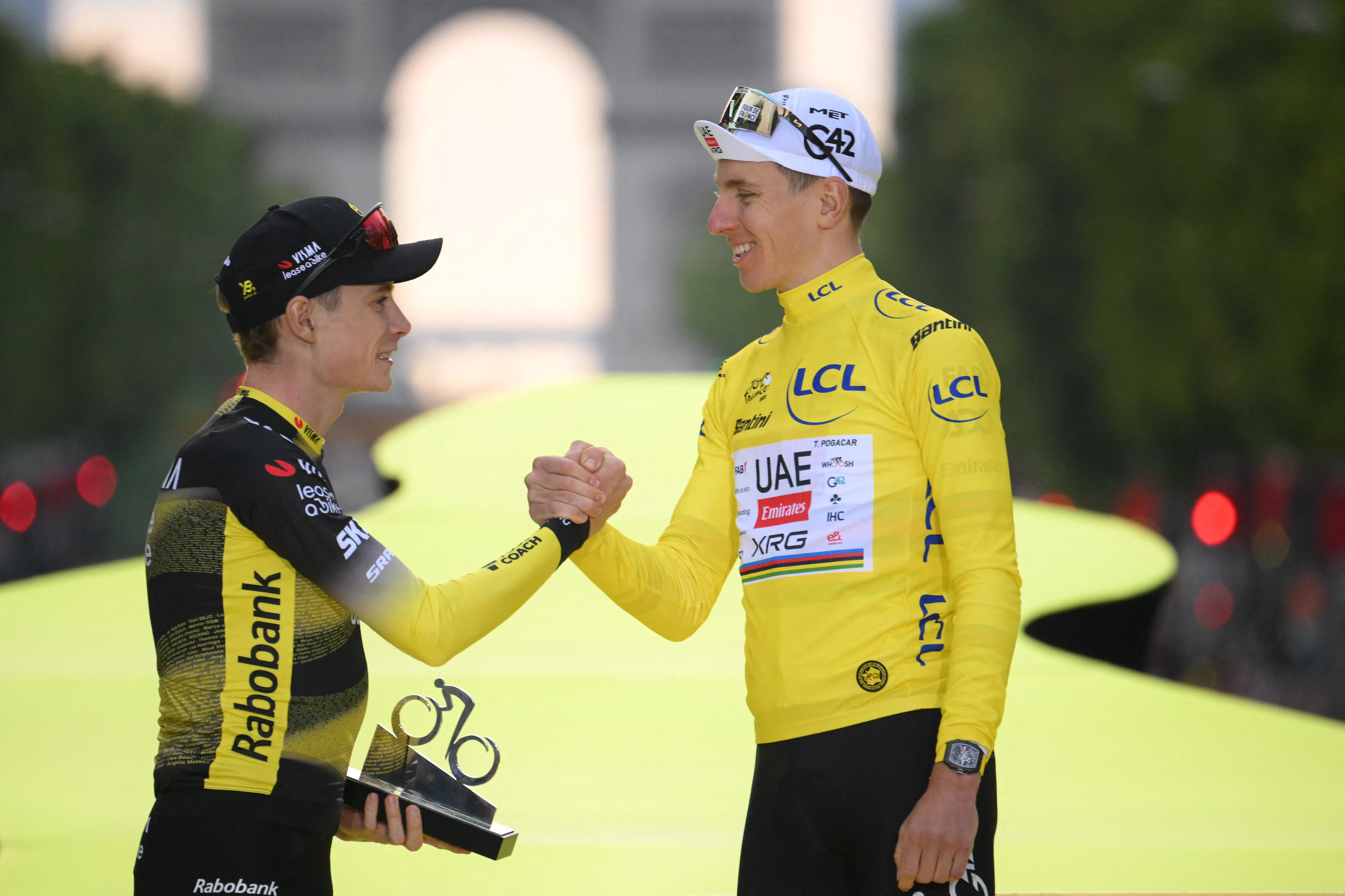 Jonas Vingegaard and Tadej Pogačar shake hands on the Tour de France podium