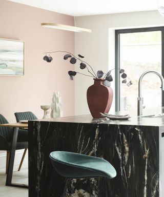 Pink kitchen with vase and green kitchen island