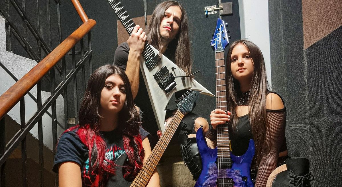 Frozen Crown&#039;s three guitarist pose with their high-performance electric guitars on a stairwell [from left] Alessia Lanzone, Federico Mondelli and Fabiola Bellomo