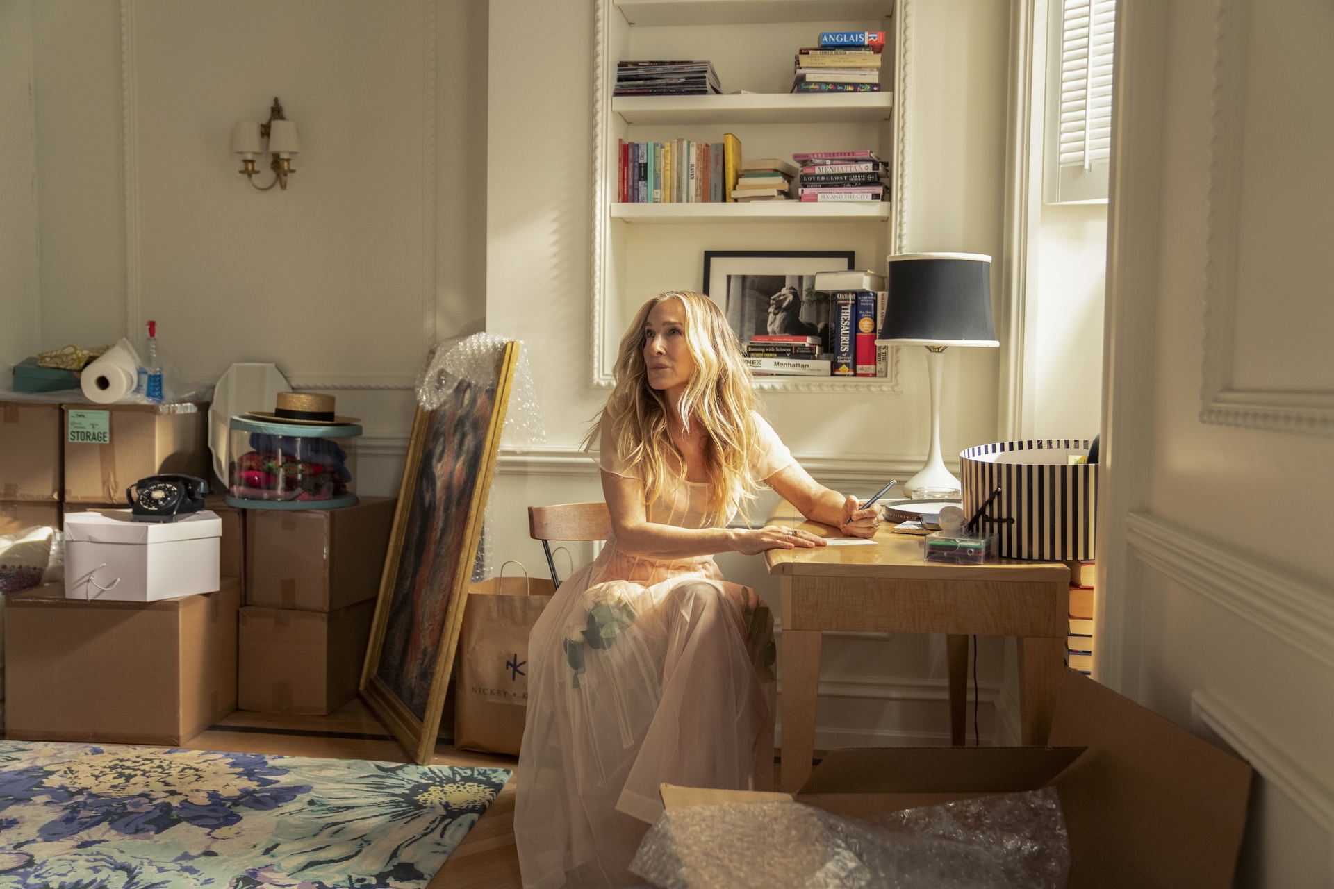 carrie bradshaw sits at a desk writing in and just like that season 3