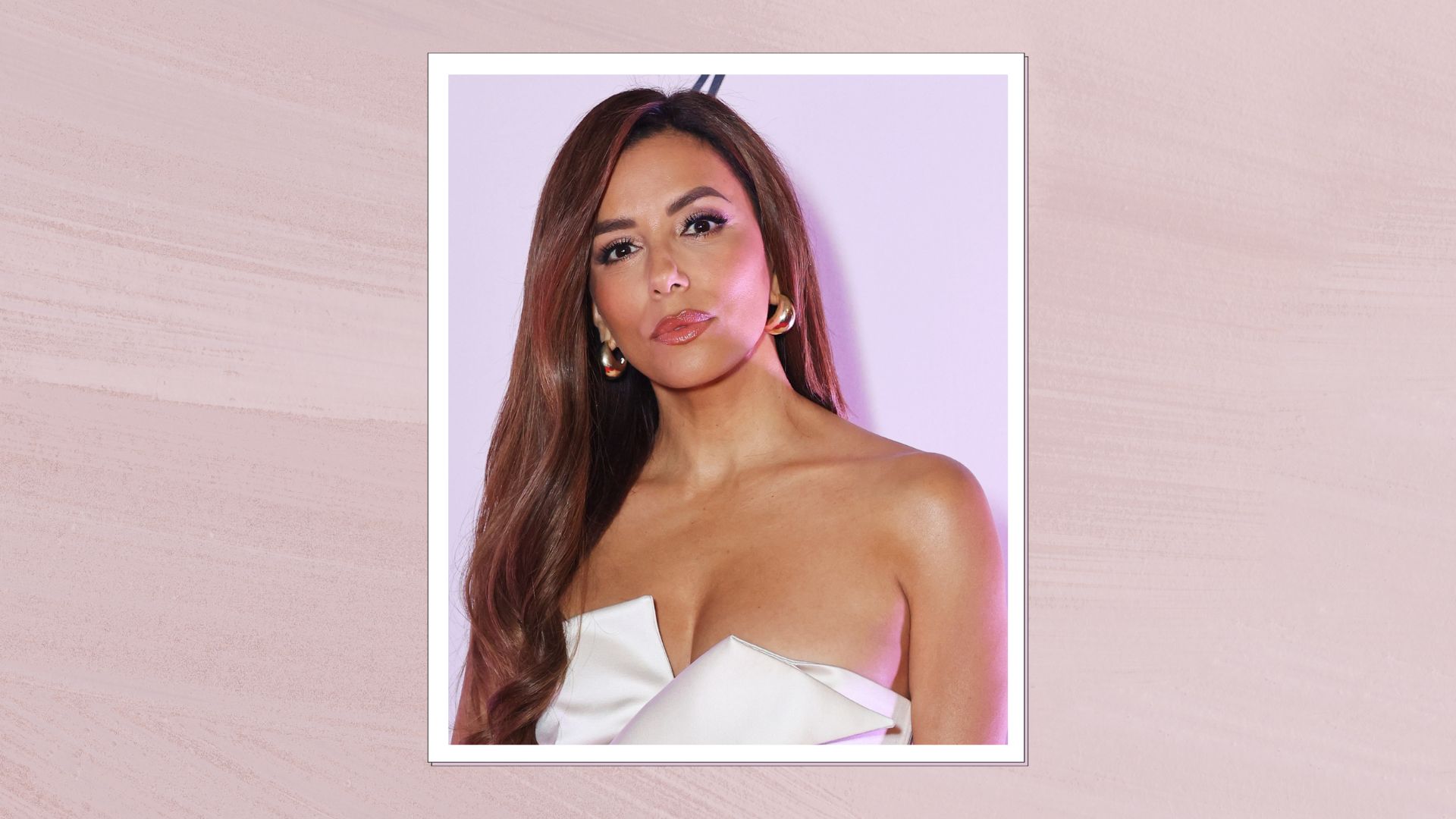Eva Longoria attends La Môme 10 year anniversary dinner celebration on May 17, 2025 in Cannes, France wearing a white asymmetric dress with glossy curled hair, pink-painted template behind photo. 