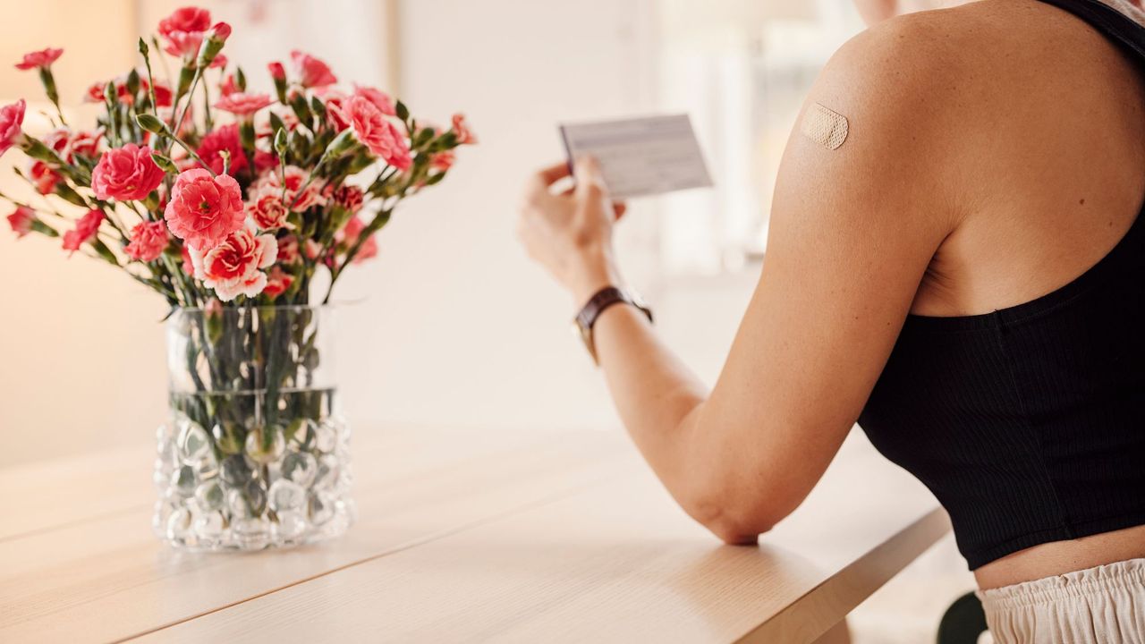 A woman wearing a wellness patch on her arm