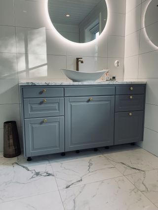 A teal toned bathroom storage unit with multiple drawers