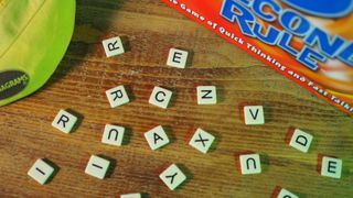 A selection of word tiles beside the Bananagrams bag and 5 Second Rule box, all on a wooden table